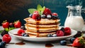 Delicious stack of pancakes with fresh berries and drizzled syrup. Tasty food for breakfast