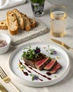 Delicious steak dinner with bread and water served on a white table for a fine dining experience Royalty Free Stock Photo