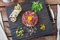 Delicious steak tartare with yolk, capers, green onion and bread