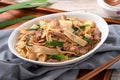 Delicious stir-fried Taiwanese Hakka flat rice noodles on white background