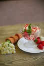 Delicious strawberry ice cream scoop with fresh strawberries on wooden background Royalty Free Stock Photo