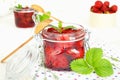 Delicious strawberry jam in traditional glass jar on white wooden background Royalty Free Stock Photo