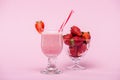 Delicious strawberry milkshake in glass with straw and fresh strawberries in bowl Royalty Free Stock Photo