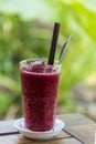 Delicious strawberry, mulberry and blueberry smoothie in glass on wood table, nature background, a healthy summer drink, well