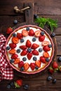 Delicious strawberry pie with fresh blueberry and whipped cream on wooden rustic table, cheesecake Royalty Free Stock Photo