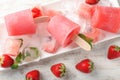 Delicious strawberry popsicles and ice cubes with berries on plate Royalty Free Stock Photo