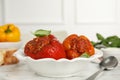 Delicious stuffed peppers with basil in bowl on white marble table Royalty Free Stock Photo