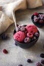 Delicious summer berries yogurt ice cream with berries on grey background, frozen berries