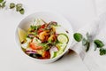 Delicious summer salad with fresh vegetables and seafood. Seasonal vegetables, shrimp and goat cheese. Healthy Mediterranean food Royalty Free Stock Photo