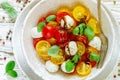 Delicious summer salad of yellow and red cherry tomatoes, mozzarella with Basil Royalty Free Stock Photo