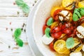 Delicious summer salad of yellow and red cherry tomatoes, mozzarella with Basil Royalty Free Stock Photo