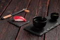 Delicious sushi maguro tuna. Nigiri with tuna on black and wooden background . Traditional Japanese cuisine Royalty Free Stock Photo