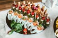 Delicious sushi rolls on black plate, decorated fruit snacks Royalty Free Stock Photo