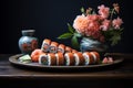 Delicious sushi rolls with flowers on plate, traditional japanese cuisine on dark background Royalty Free Stock Photo