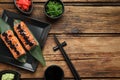 Delicious sushi rolls served on wooden table, flat lay. Space for text Royalty Free Stock Photo