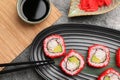 Delicious sushi rolls, soy sauce, ginger and chopsticks on grey textured table, flat lay Royalty Free Stock Photo