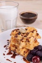 sweet Belgian waffles in the form of hearts with chocolate and berries with a glass of milk. breakfast. on a natural wooden backg Royalty Free Stock Photo