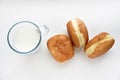 Delicious sweet buns with jam and a glass of milk on a white background. A delicious breakfast of beautifully fried buns and milk Royalty Free Stock Photo