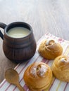 Delicious sweet buns with milk for breakfast. Milk is poured into a clay mug. Rustic food Royalty Free Stock Photo