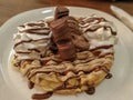 Delicious sweet dessert closeup round crispy belgian waffle and chocolate toppings with ice cream and whipped cream served with