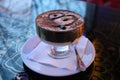 A delicious, sweet dessert of tiramisu in a crockery on a table in a cafe in the evening Royalty Free Stock Photo