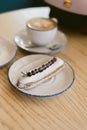 delicious sweet french eclairs and coffee in a coffee shop. Morning breakfast on a light table. Royalty Free Stock Photo