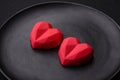 Delicious sweet heart shaped chocolate candies on a dark concrete background