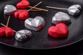 Delicious sweet heart shaped chocolate candies on a dark concrete background