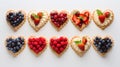 Delicious sweet heart-shaped tartlets with strawberries, raspberries, blueberries on light background