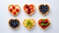 Delicious sweet heart-shaped tartlets with strawberries, raspberries, blueberries on light background