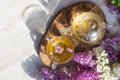 Delicious sweet herbal tea with lilac scent, glass cup and teapot with hot drink