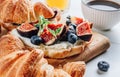 Delicious sweet sandwich with croissants, soft cheese, blueberries and figs