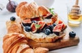 Delicious sweet sandwich with croissants, soft cheese, blueberries and figs
