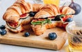 Delicious sweet sandwich with croissants, soft cheese, blueberries and figs