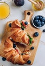 Delicious sweet sandwich with croissants, soft cheese, blueberries and figs