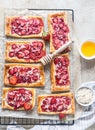 Delicious sweet sliced pies with strawberry. Puff pastry mini pies with strawberry, cream cheese, almond and honey. Top view