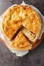 Delicious Swiss cholera pie with apple, potato, pear, onion and cheese close-up on a wooden board on the table. Vertical top view