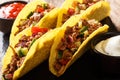 Delicious tacos stuffed with minced beef and vegetables served with sauces close-up on a slate table. Horizontal Royalty Free Stock Photo