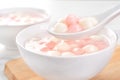 Delicious tang yuan, red and white rice dumpling balls in a small bowl. Asian traditional festive food for Chinese Winter Solstice