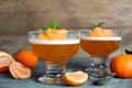 Delicious tangerine jelly and fresh fruits on light blue wooden table, closeup Royalty Free Stock Photo