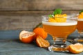 Delicious tangerine jelly and fresh fruits on light blue wooden table, closeup Royalty Free Stock Photo