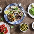 Delicious tapas - sandwiches with sardines, mussels, octopus, grape, tomato and avocado on wooden table Royalty Free Stock Photo