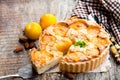 Delicious tart with yellow plum and almonds on wooden table