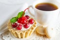Delicious tartlet with fresh berries and cream cheese, a ÃÂup of tea and small cookies