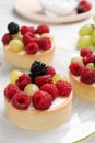 Delicious tartlets with berries on plate, closeup