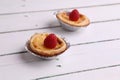 Delicious tarts on a wooden table topped with raspberry