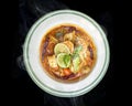 Delicious Thai foods of Tom Yam Kung (Thai cuisine), Hot Thai food on the black background with smoke.Top view of Thai Royalty Free Stock Photo