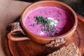 Delicious thick purple beetroot soup kefir cultured buttermilk, dill, table dish clay with pattern. Tureen, plate, bread