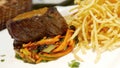 Delicious thick steak, salad and fries on meal dish