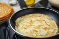 Delicious thin pancake in frying pan on induction stove